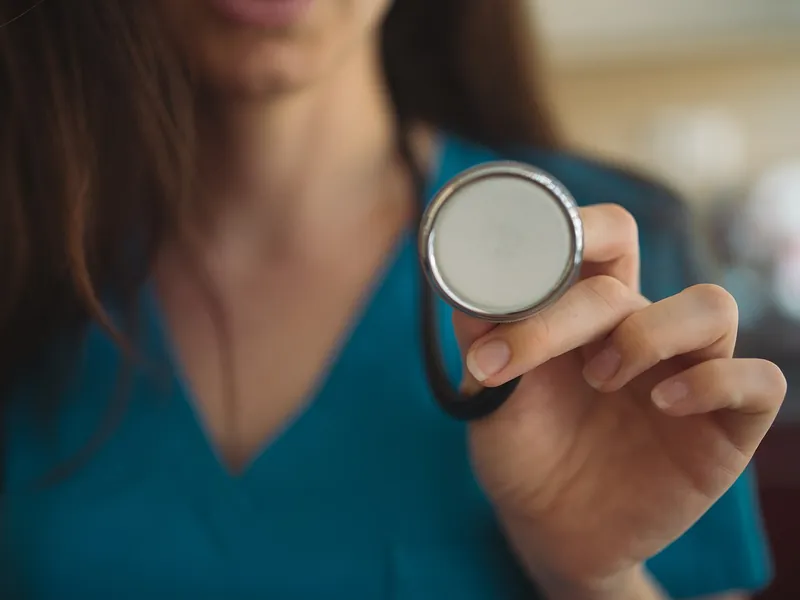 Young nurse holding a stethoscope closeup